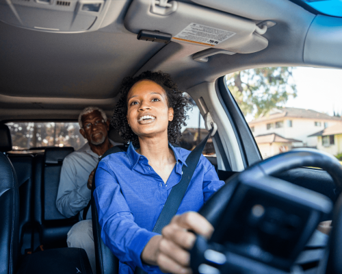 Rideshare driver with a passenger in the back seat operates a vehicle, illustrating a typical Uber or Lyft scenario where liability can become complex in Oklahoma City accident claims.