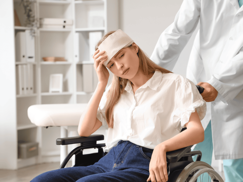 Young woman with a head injury sitting in a wheelchair while receiving medical care, illustrating the link between traumatic brain injuries and depression in Oklahoma City personal injury claims.